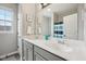 Bright bathroom featuring a double vanity with grey cabinetry and a large mirror at 1442 Avondale Dr, Westfield, IN 46074