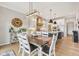 Dining area showcasing a wooden table, white chairs, stylish lighting, and an open layout to the kitchen at 1442 Avondale Dr, Westfield, IN 46074