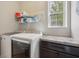 Functional laundry room with modern appliances, counter space, and a bright window for natural light at 1442 Avondale Dr, Westfield, IN 46074