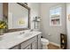 Charming powder room with modern vanity, decorative mirror, and natural light from the window at 1442 Avondale Dr, Westfield, IN 46074