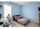Comfortable bedroom with bright blue walls, a plaid bedspread, and a stylish gaming chair at 15250 Mooring E Cir, Carmel, IN 46033