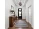 Grand foyer features hardwood floors, modern light fixture, and rustic wood accent table at 15250 Mooring E Cir, Carmel, IN 46033