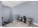Upstairs hallway features neutral carpet and paint, with two chairs for relaxing and a stairwell at 15250 Mooring E Cir, Carmel, IN 46033