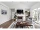 Bright living room with fireplace, TV, shelves, and view to the outside at 15250 Mooring E Cir, Carmel, IN 46033