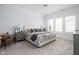 Serene main bedroom featuring calming blue walls, plush carpet, and ample natural light from large windows at 15250 Mooring E Cir, Carmel, IN 46033