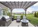 Outdoor patio with pergola, grill, fire pit, and scenic view of the community pond at 15250 Mooring E Cir, Carmel, IN 46033