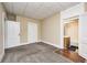 Bedroom featuring tan colored walls, soft carpet, and entryways to two different rooms at 156 S Cross St, Clayton, IN 46118