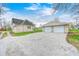 View of the home and a detached two-car garage with a gravel driveway at 156 S Cross St, Clayton, IN 46118