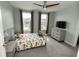 Comfortable bedroom featuring a ceiling fan, large windows, dresser, and stylish decor at 15958 Oakhurst Ln, Fishers, IN 46040
