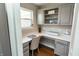 Bright home office featuring custom gray cabinets, quartz counters, and a view to the outdoors at 15958 Oakhurst Ln, Fishers, IN 46040