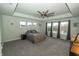 Main bedroom with tray ceiling, a ceiling fan, and large windows overlooking the backyard pond at 15958 Oakhurst Ln, Fishers, IN 46040