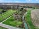 This aerial view showcases lush meadows and a serene creek alongside a paved country road at 2025 State Road 47, Lebanon, IN 46052