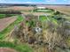 A panoramic aerial view capturing the home nestled among fields and a winding creek at 2025 State Road 47, Lebanon, IN 46052
