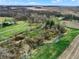 An aerial view of a winding creek and the property's expansive green fields at 2025 State Road 47, Lebanon, IN 46052