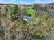 Aerial view showcases a charming home nestled among trees, near a tranquil stream at 2025 State Road 47, Lebanon, IN 46052