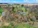 A high angle aerial perspective of the property bordered by a winding creek and surrounding fields at 2025 State Road 47, Lebanon, IN 46052