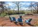 Backyard scene with Adirondack chairs gathered around a fire pit next to a creek at 2025 State Road 47, Lebanon, IN 46052