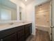 This bright bathroom offers a double sink vanity and a shower over tub at 211 Ames Dr, Whiteland, IN 46184