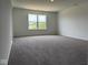 Bright bedroom featuring plush carpet, neutral walls, and a large window with green view at 211 Ames Dr, Whiteland, IN 46184