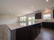 Expansive kitchen featuring a large island, dark cabinets, and modern appliances at 211 Ames Dr, Whiteland, IN 46184