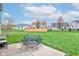 A patio area with a table and seating, surrounded by a lush, well-maintained lawn at 2209 Foxfire Ct, Greenfield, IN 46140