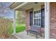 Covered front porch with black bench and brick pillars at 2209 Foxfire Ct, Greenfield, IN 46140