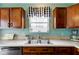 Well-lit kitchen with modern sink, wooden cabinets, and a window providing natural light and backyard views at 2209 Foxfire Ct, Greenfield, IN 46140