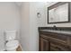 Cozy powder room features a wood vanity with a granite countertop and updated fixtures at 2405 Providence Ct, Greenwood, IN 46143