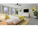Bright bedroom features a ceiling fan, carpet flooring, large windows, modern dresser, wall art and stylish decor at 2405 Providence Ct, Greenwood, IN 46143