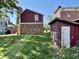 Spacious backyard featuring green grass, mature trees, brick exterior, and storage shed at 303 S Walnut St, Edinburgh, IN 46124