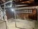 Spacious unfinished basement with exposed ductwork, concrete floor, and wood paneling, providing ample storage potential at 303 S Walnut St, Edinburgh, IN 46124