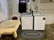 Basement laundry area with a washer, dryer, utility table, and concrete floor, offering functionality and convenience at 303 S Walnut St, Edinburgh, IN 46124