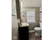 Neutral bathroom featuring a single sink vanity, marble countertop, framed artwork and a window allowing natural light at 303 S Walnut St, Edinburgh, IN 46124