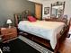 Bedroom with a dark accent wall, hardwood floors, and a wrought iron bed frame at 303 S Walnut St, Edinburgh, IN 46124