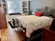 Bedroom with window seat, hardwood floors, and a decorative wrought iron bed frame at 303 S Walnut St, Edinburgh, IN 46124