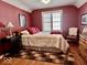 Warm bedroom boasts hardwood floors, a large window, and stylish decor at 303 S Walnut St, Edinburgh, IN 46124