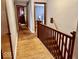 Hallway view of hardwood floors, banister, and access to bedrooms at 303 S Walnut St, Edinburgh, IN 46124