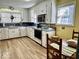 Well-lit kitchen featuring white cabinets, essential appliances, and hardwood floors at 303 S Walnut St, Edinburgh, IN 46124