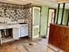 Retro kitchen featuring dated cabinetry, a stove, a sink and wallpaper, presenting an opportunity for renovation at 303 S Walnut St, Edinburgh, IN 46124
