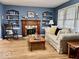 Bright living room with fireplace, built-in shelves, hardwood flooring, and neutral sofa at 303 S Walnut St, Edinburgh, IN 46124