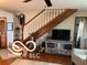 The living room includes stairs, an entertainment center, and a comfortable armchair at 3030 N 600 E, Lebanon, IN 46052