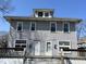 Two-story home featuring a gray exterior and a porch with railing at 3046 Central Ave, Indianapolis, IN 46205
