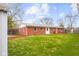 Brick home's exterior with a green lawn and mulch bed leading to a cozy red deck at 3104 S Pisgah Way, Columbus, IN 47203