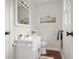 Bathroom with white vanity, toilet, and mirror; modern barn painting above at 3104 S Pisgah Way, Columbus, IN 47203