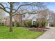 Beautiful two-story brick and white home featuring mature trees and landscaped front yard at 325 W Greyhound Pass, Carmel, IN 46032