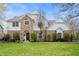 Charming brick and white two-story home with well-manicured lawn and lush landscaping at 325 W Greyhound Pass, Carmel, IN 46032