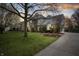 Well-maintained two-story home with lush green lawn and mature trees, set against a twilight sky at 325 W Greyhound Pass, Carmel, IN 46032