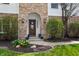 Elegant front entry with brick archway, decorative door, and neatly arranged flower pots at 325 W Greyhound Pass, Carmel, IN 46032