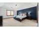Serene main bedroom with a striking blue accent wall, comfortable bed, and soft carpeting at 325 W Greyhound Pass, Carmel, IN 46032