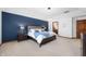 Spacious main bedroom with a bold blue accent wall, plush carpeting, and elegant furnishings at 325 W Greyhound Pass, Carmel, IN 46032